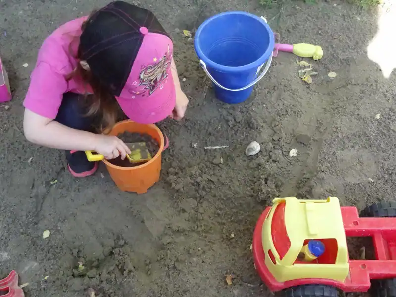 Gallery 4 Young child engaging in outdoor sandbox play with toys at Diana Daycare Newmarket.