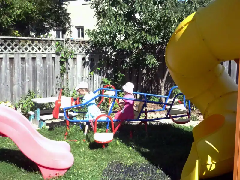 Gallery 7 Children playing on colorful outdoor playground equipment in a safe, sunny yard.